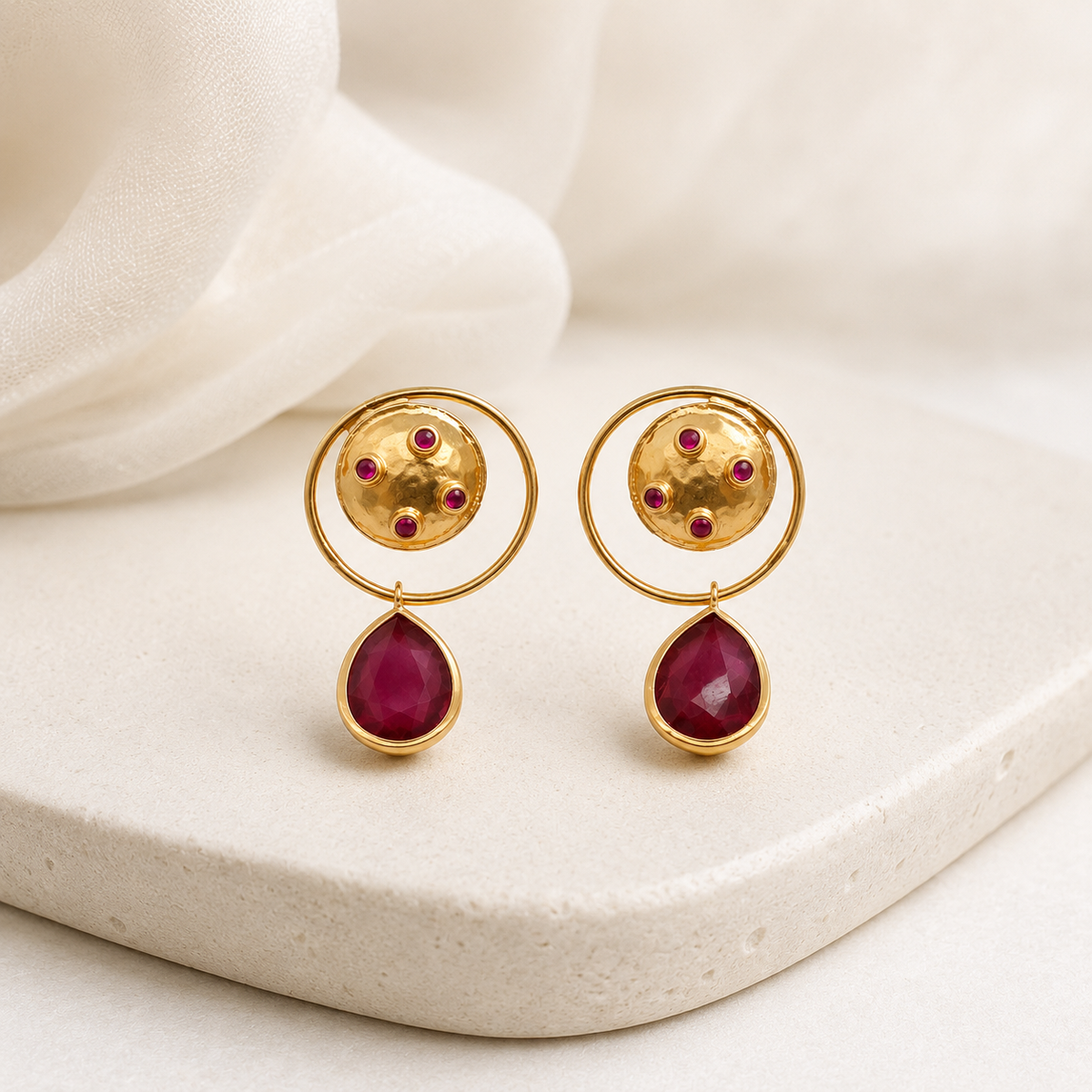 Gold-plated dangle earrings with a circular top, magenta accents, and a teardrop drop.