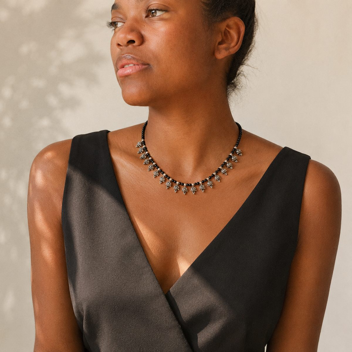 Black bead necklace with silver-tone accents in a clean product image.