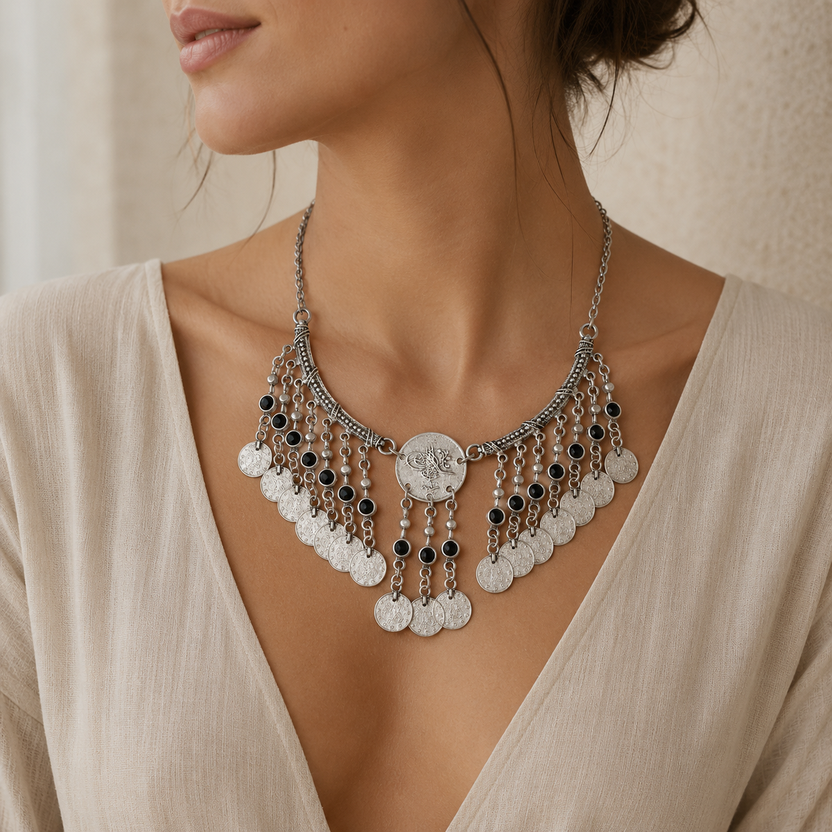 Antique silver necklace with ornate coin fringe and black stone drops.