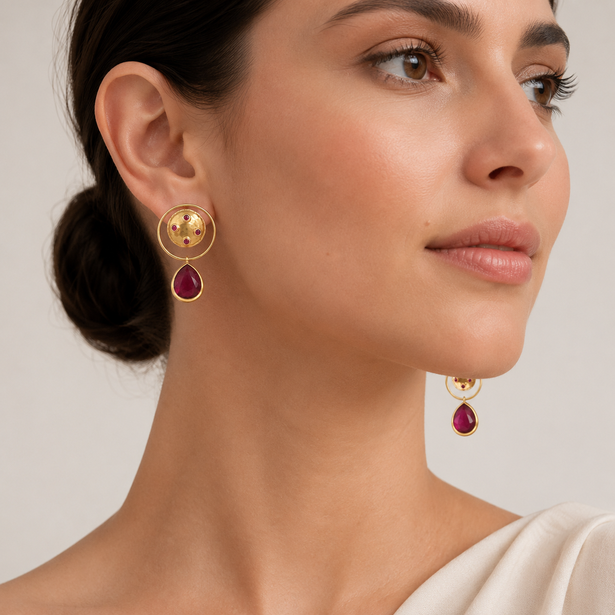 Gold-plated dangle earrings with a circular top, magenta accents, and a teardrop drop.