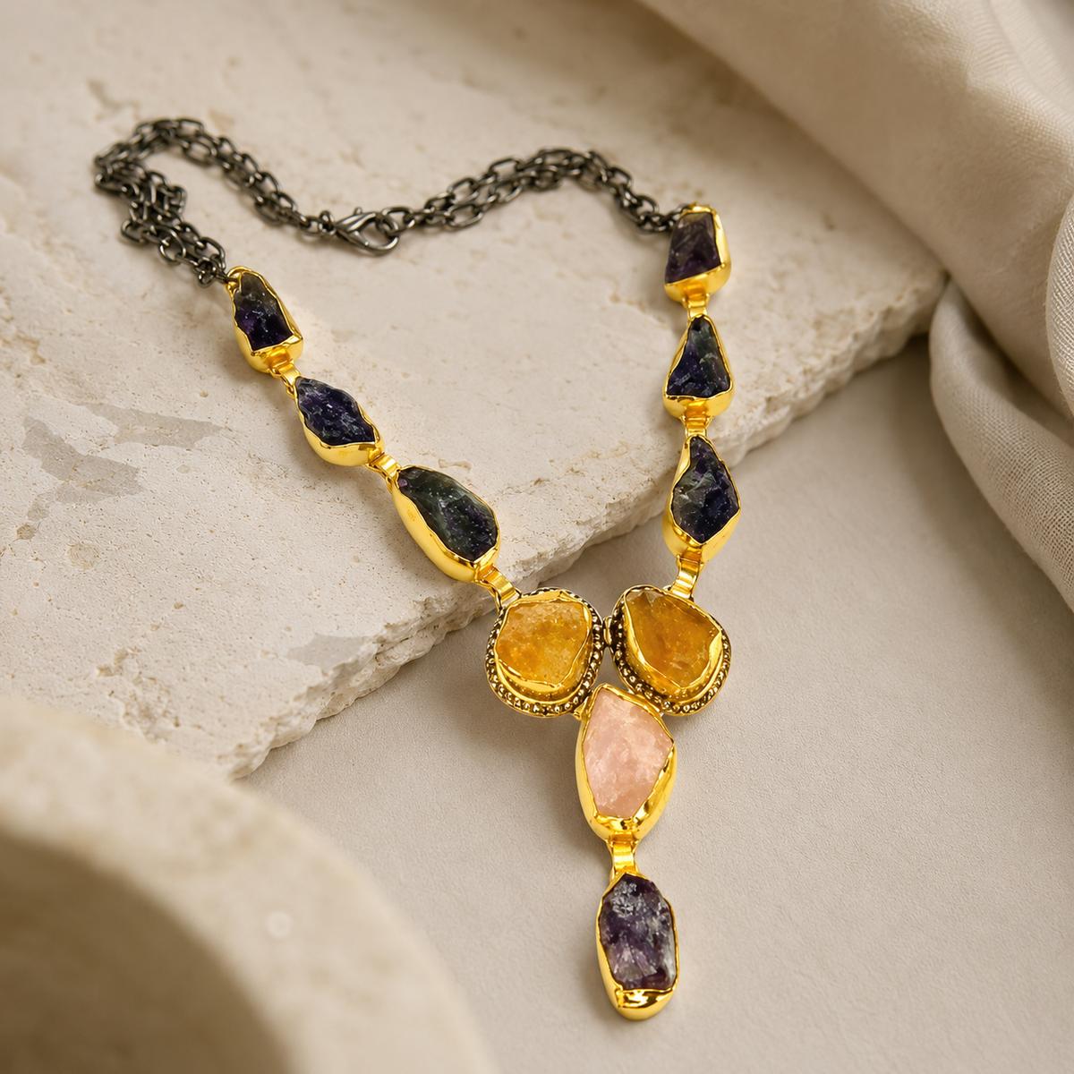 Angle view of the mixed gemstone Y drop necklace with gold-tone links and stone accents.