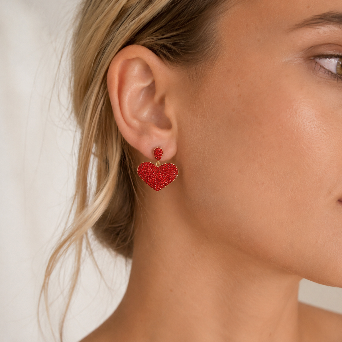 Red crystal heart stud earrings with a gold-plated finish shown from the front.