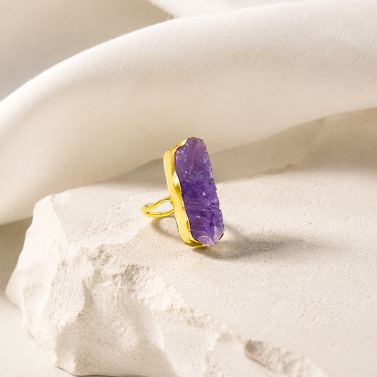 Gold-plated statement ring with a long raw amethyst stone.