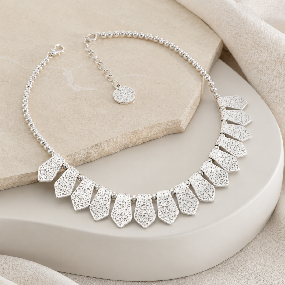 Angled view of a silver-tone necklace with spear-shaped drops.