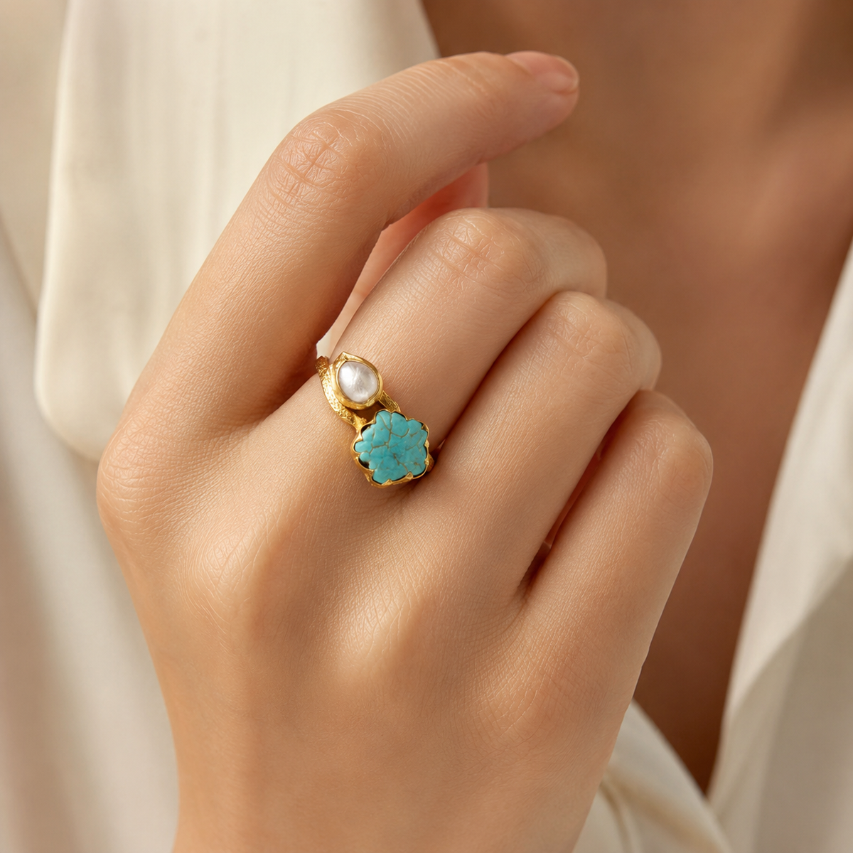 Gold-plated two-stone ring with turquoise and pearl-like details.
