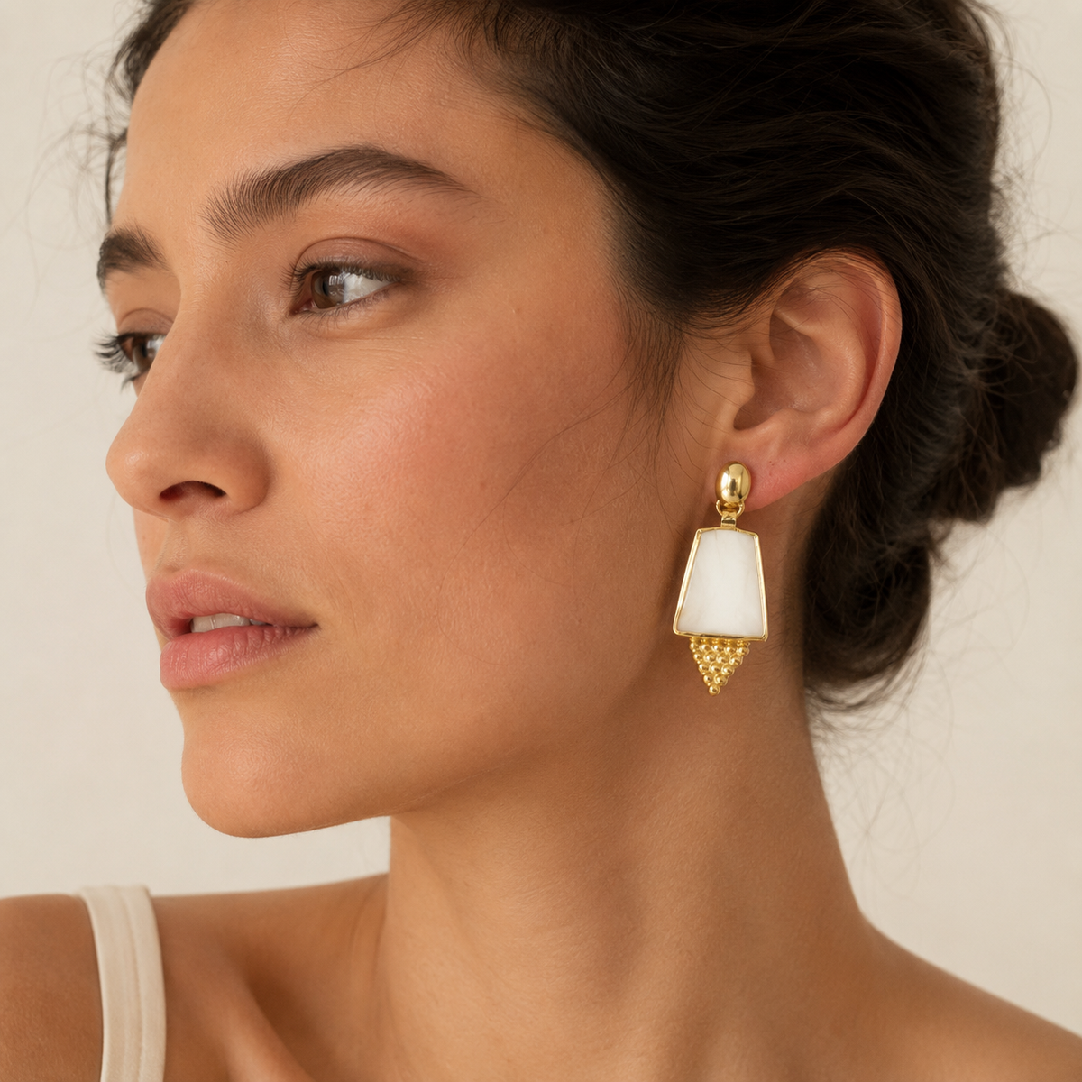 Gold-plated drop earrings with a sculptural shield silhouette and pearl-like panels.