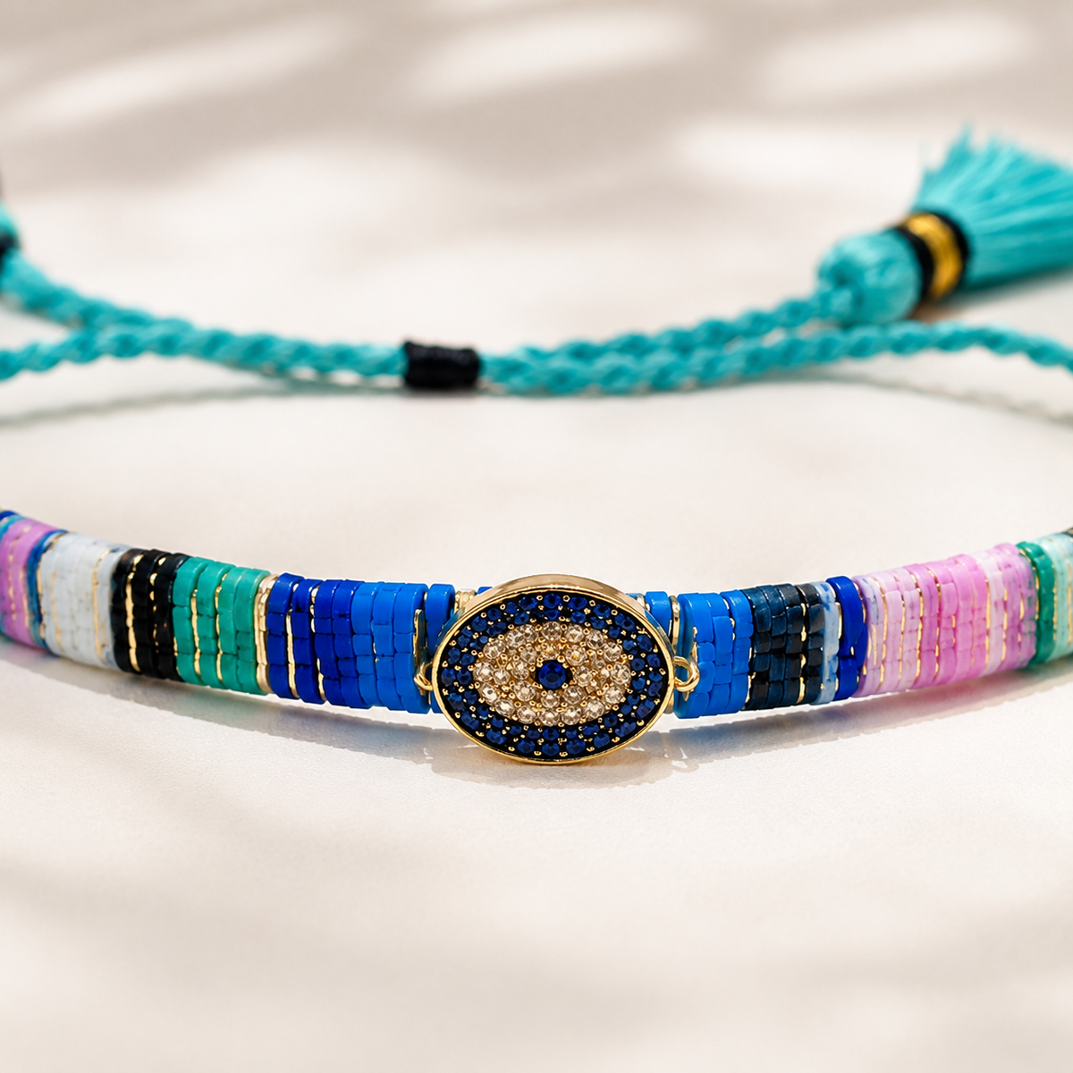 Close view of the bracelet’s woven threads and centered evil eye accent.