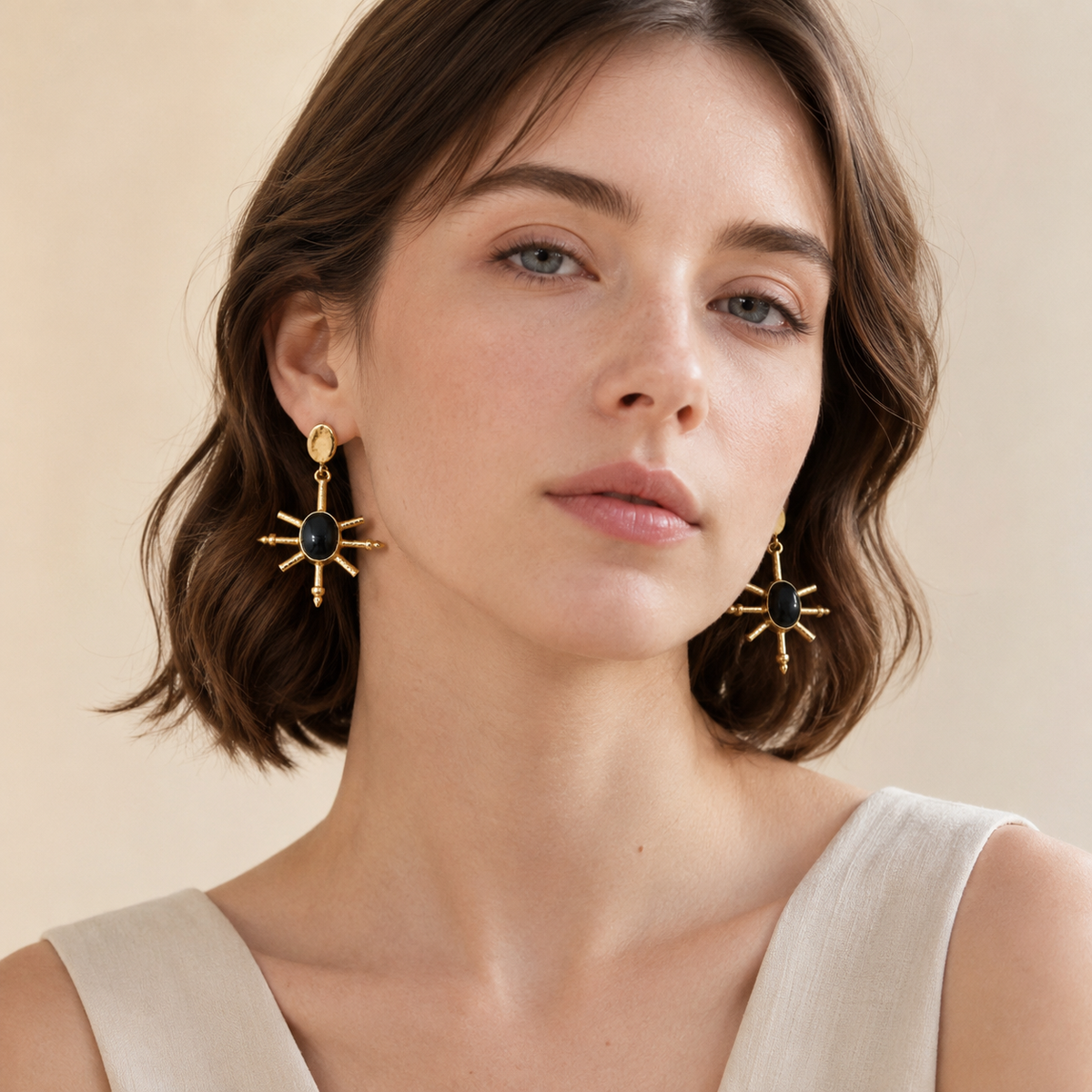 Gold-plated statement earrings with black onyx centers shown from the front.