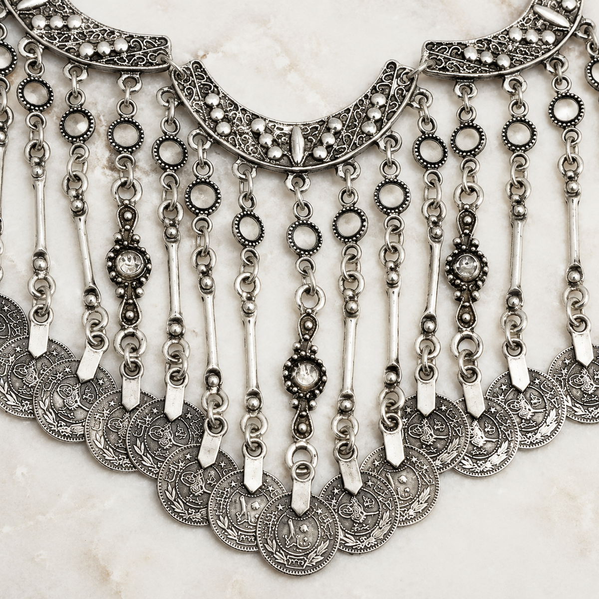 Close view of the textured silver-tone crescent and coin details.