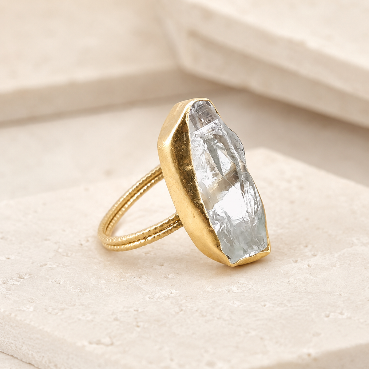 Side angle view of a raw crystal quartz gold-plated statement ring.