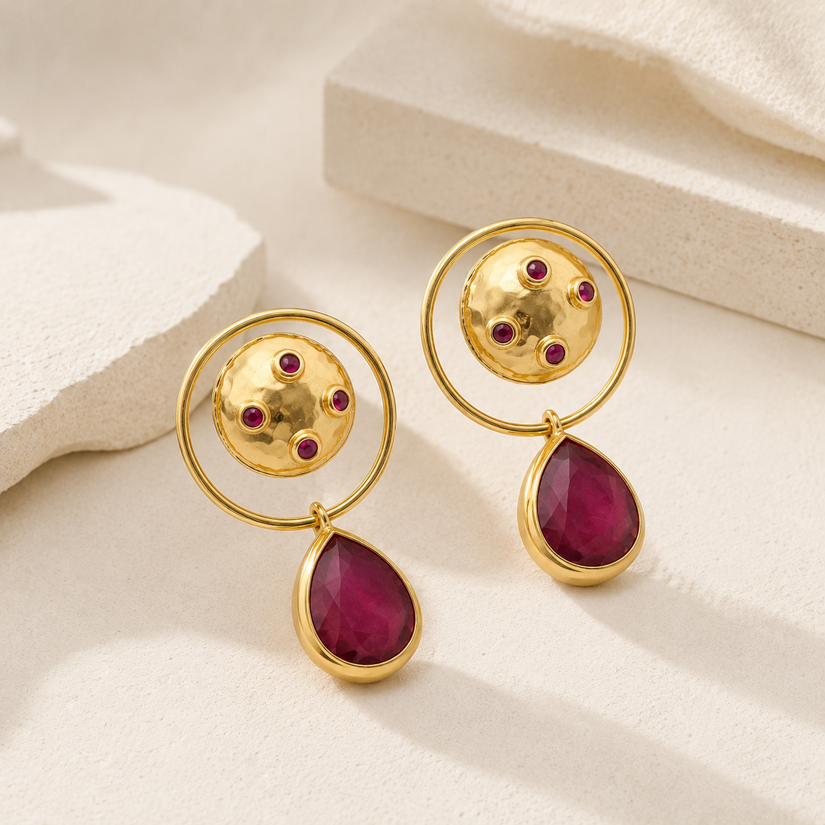 Gold-plated dangle earrings with a circular top, magenta accents, and a teardrop drop.