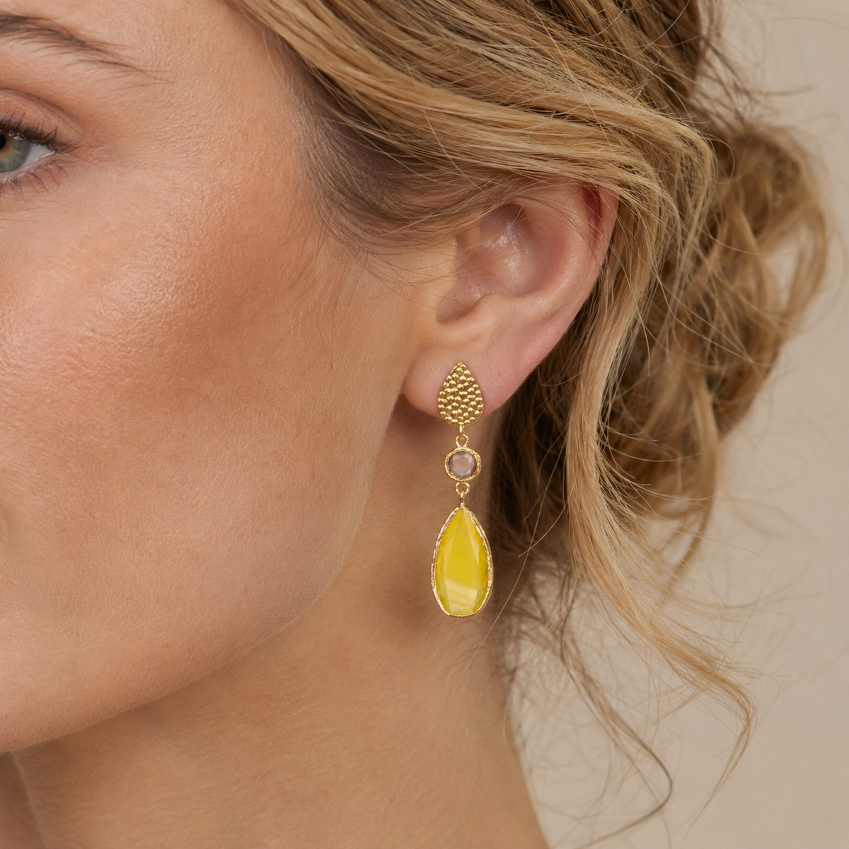 Gold-plated drop earrings with a textured teardrop shape and long yellow stone drops.