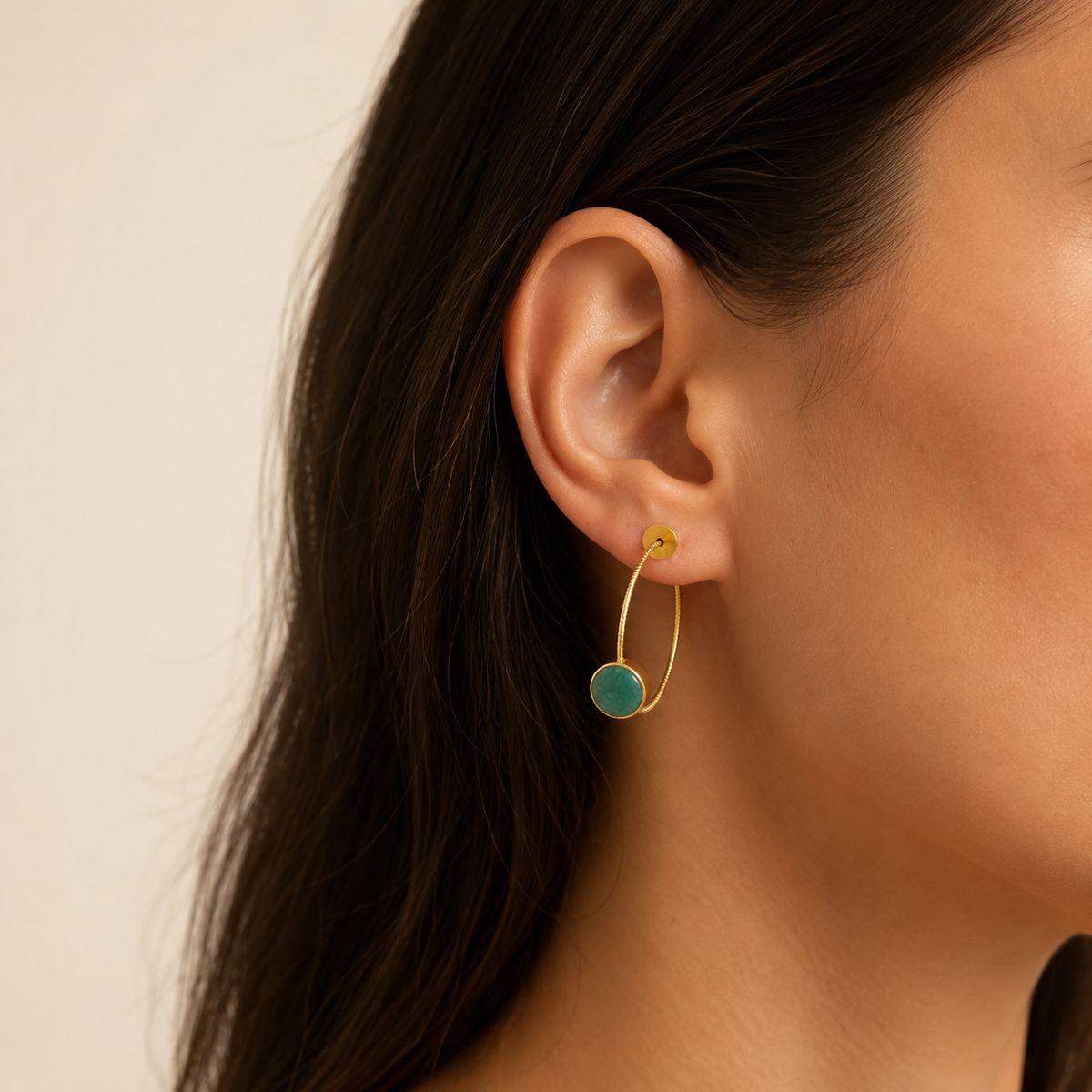 Gold-plated hoop earrings with green aventurine discs shown from the front.
