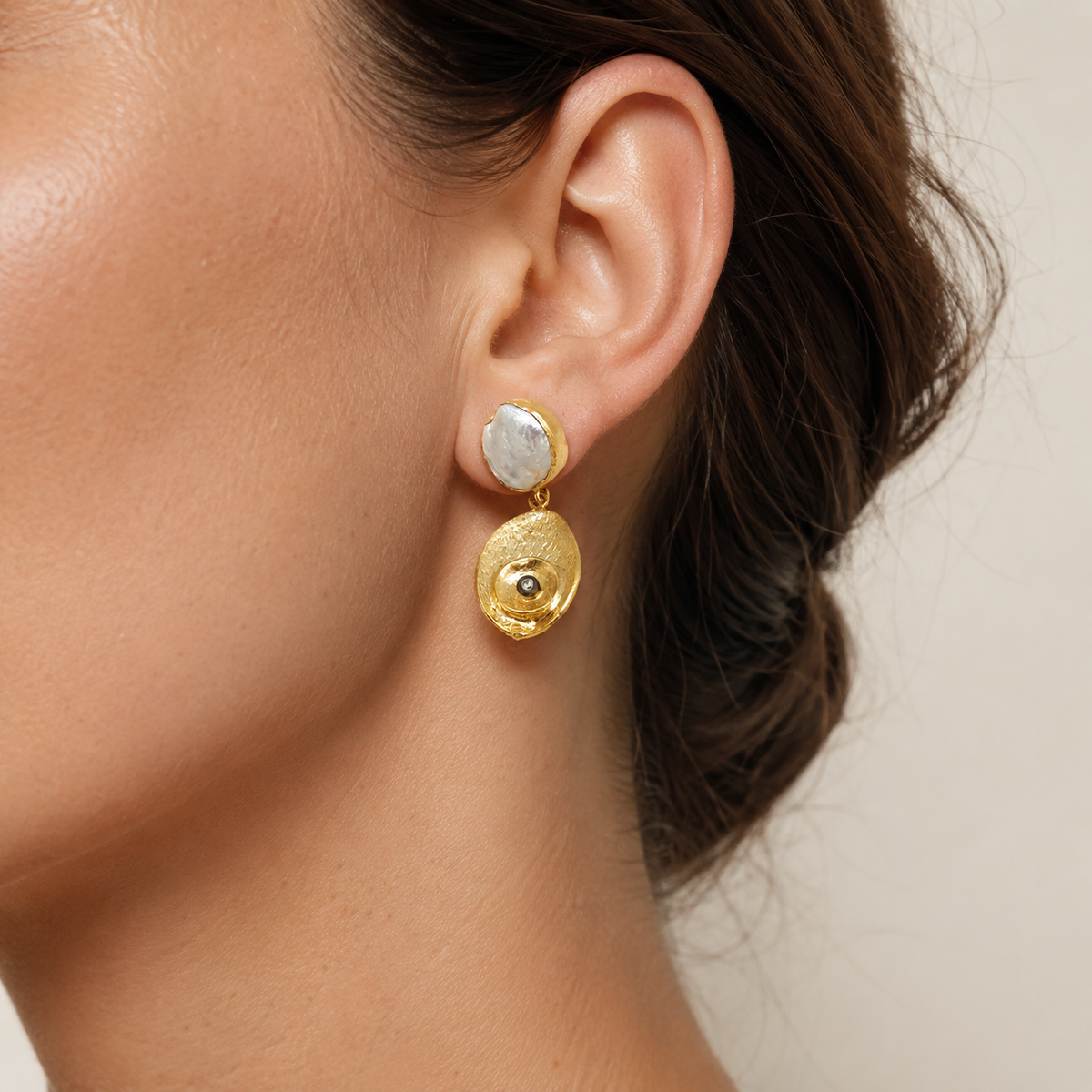 Pearl-like oval drop earrings shown from the front.
