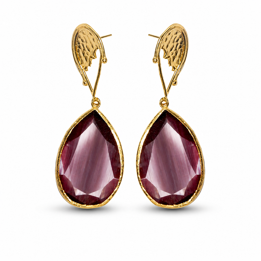 Close-up of a purple teardrop stone and gold-plated setting.