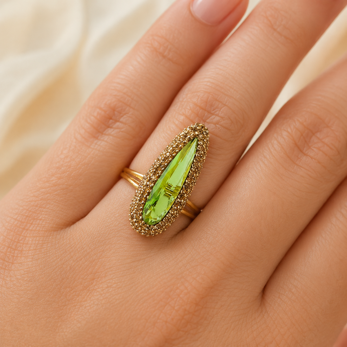 Gold-tone ring with a vivid green marquise-cut stone shown from the front.