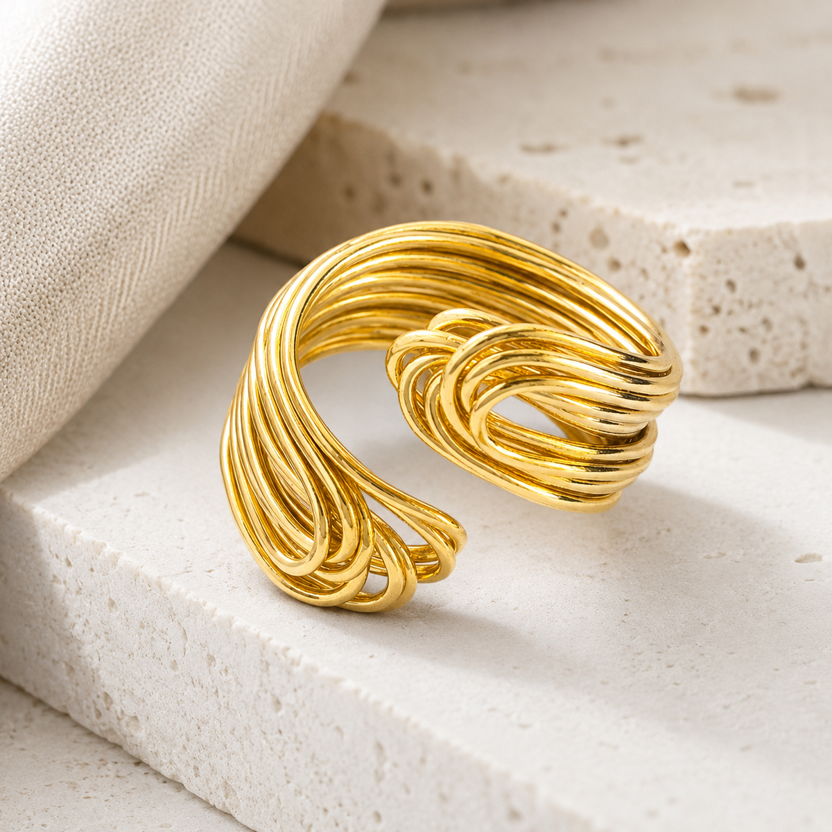 Angled view of a layered gold-plated knot statement ring.