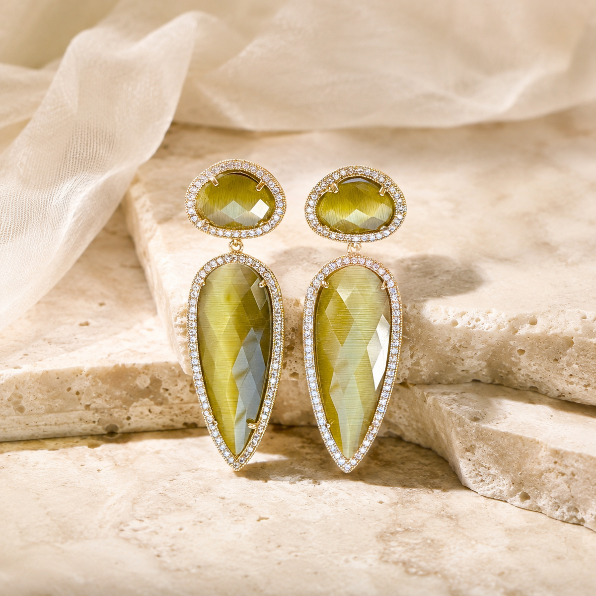 Olive teardrop earrings with a faceted stone look and sparkling border detail.