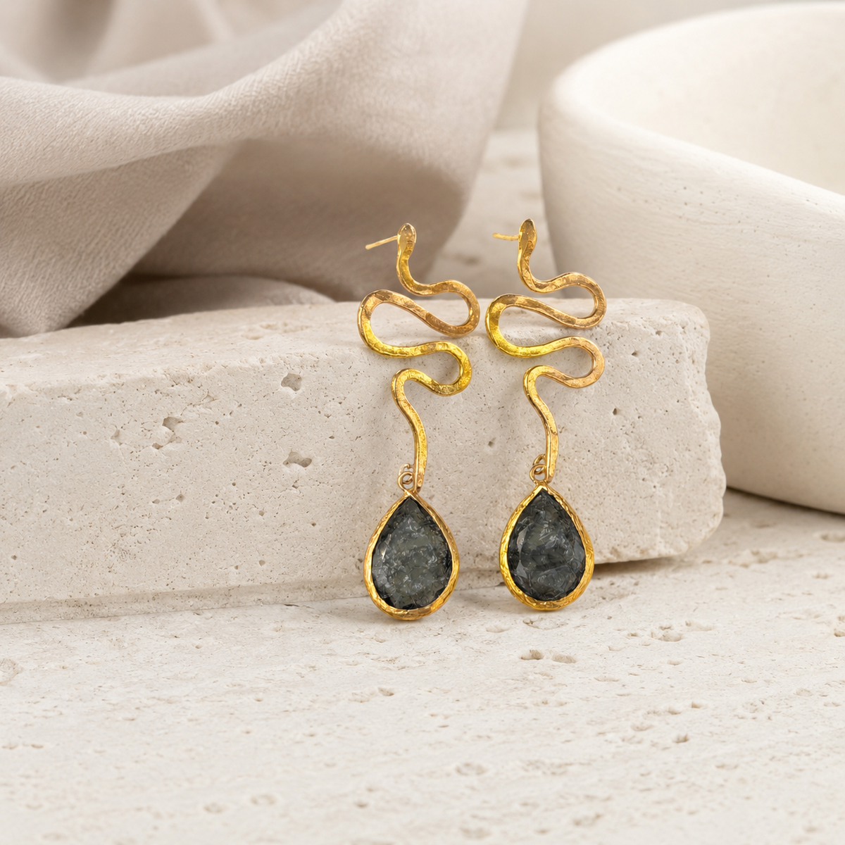 Gold-plated snake shape dangle earrings with a sculptural teardrop design.