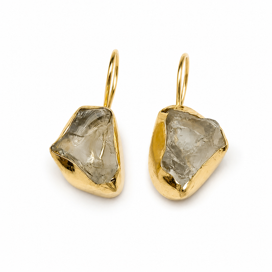 Raw amethyst drop earrings with a gold-plated setting on a white background.