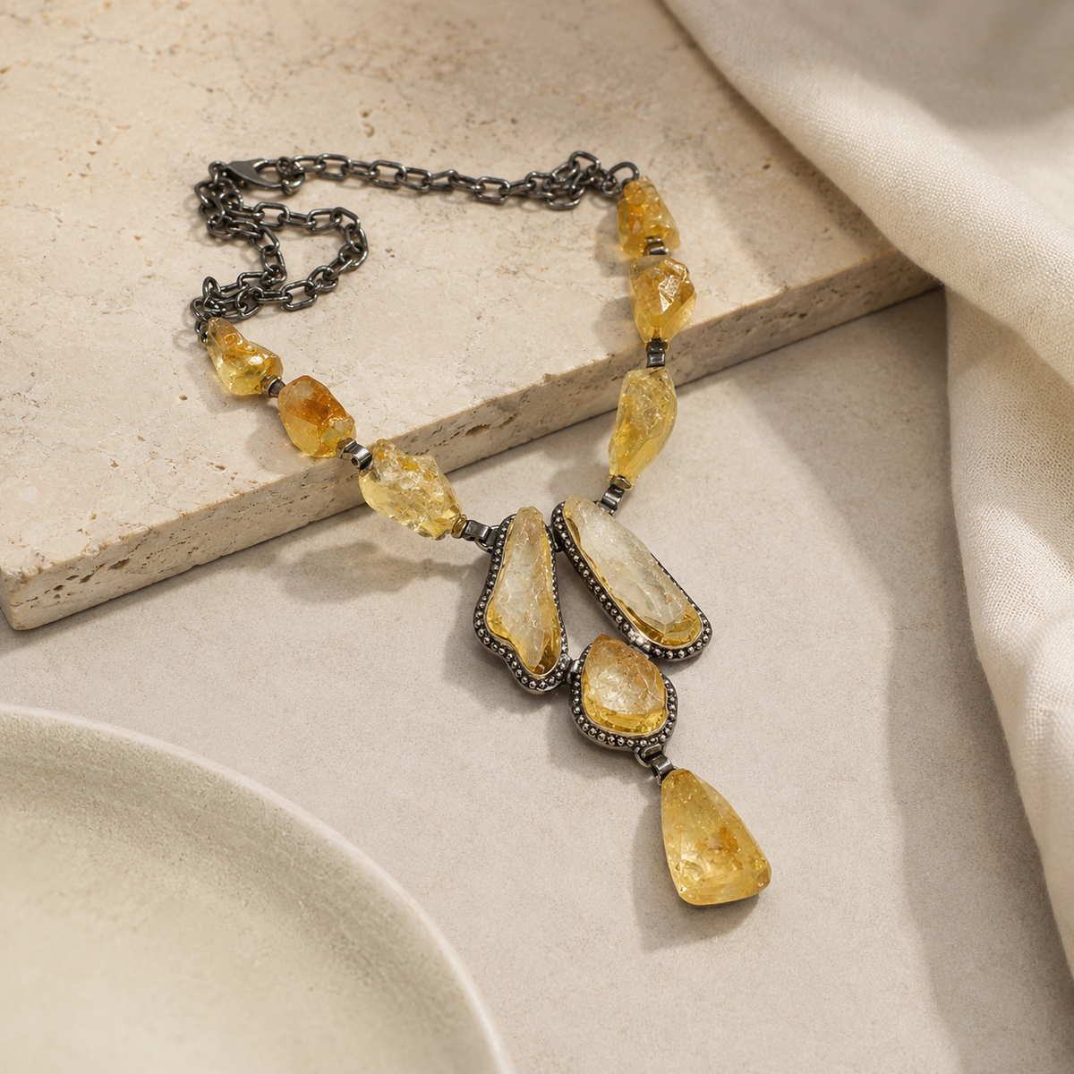 Angle view of a raw citrine necklace with a gold-tone chain.