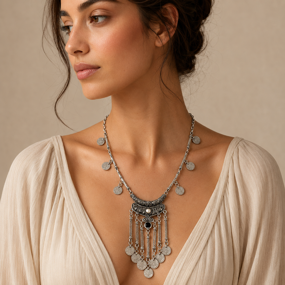 Silver-tone necklace with a detailed coin pendant and black stone accent.