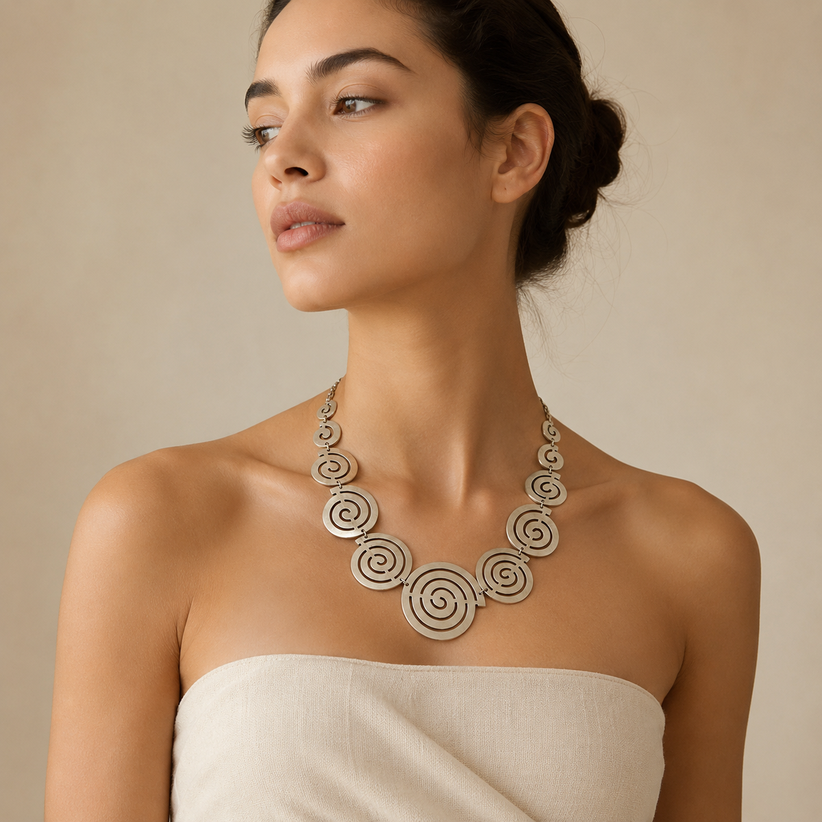 Statement necklace with layered spiral circle pendants in a soft gold-tone finish.