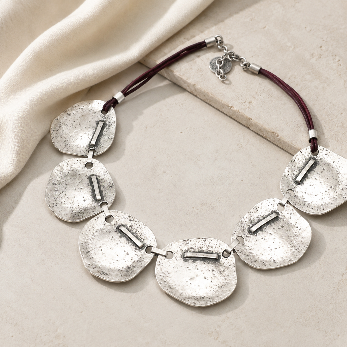 Hammered silver plate necklace with a bold, modern silhouette.