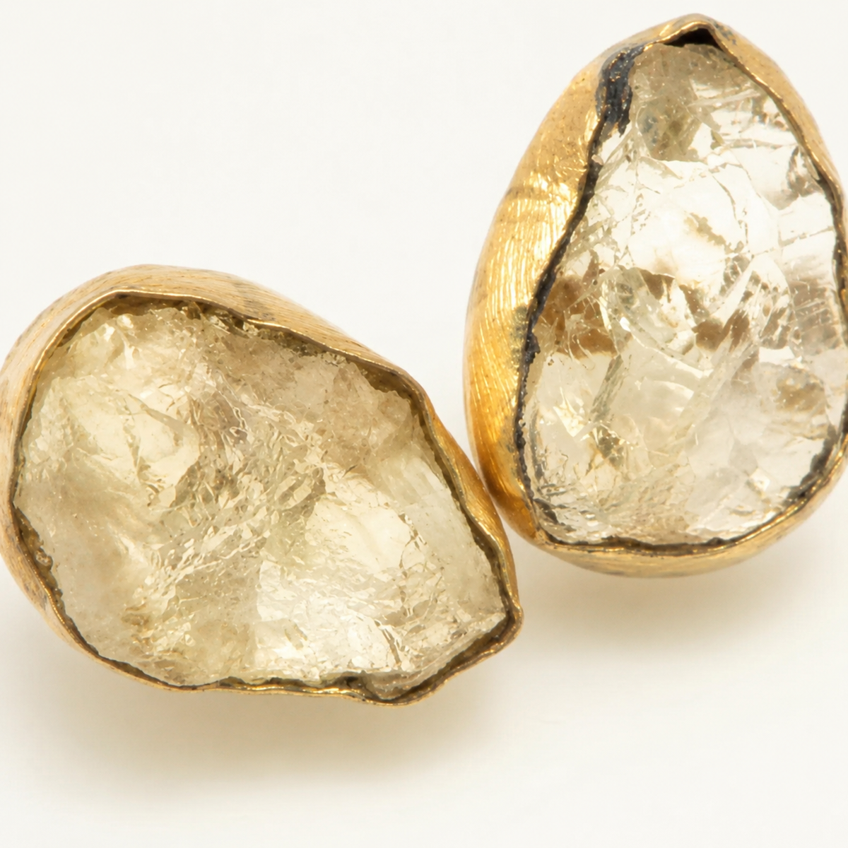 Close view of raw quartz stones framed in gold-plated metal.