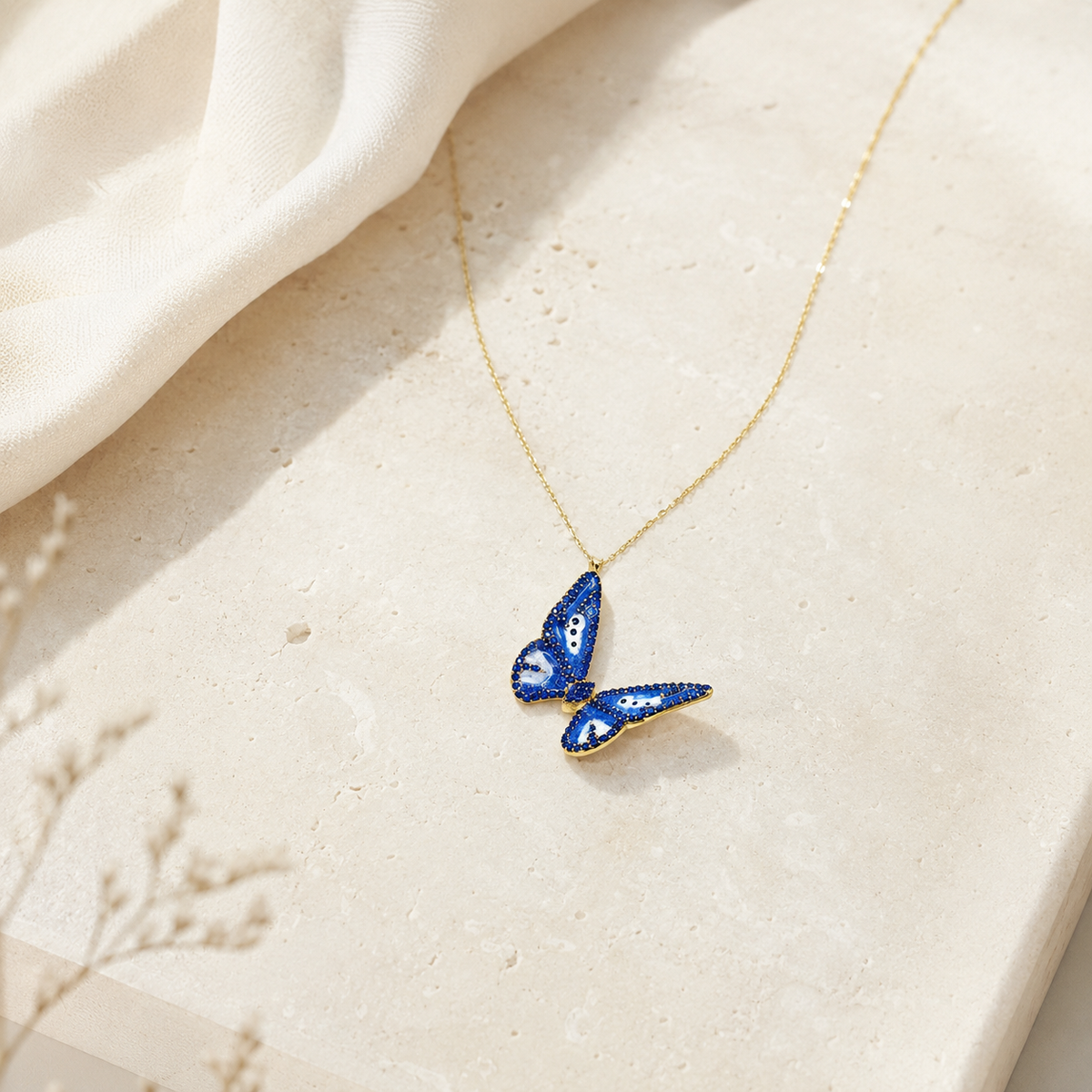 Butterfly pendant necklace with a slim gold-tone chain.