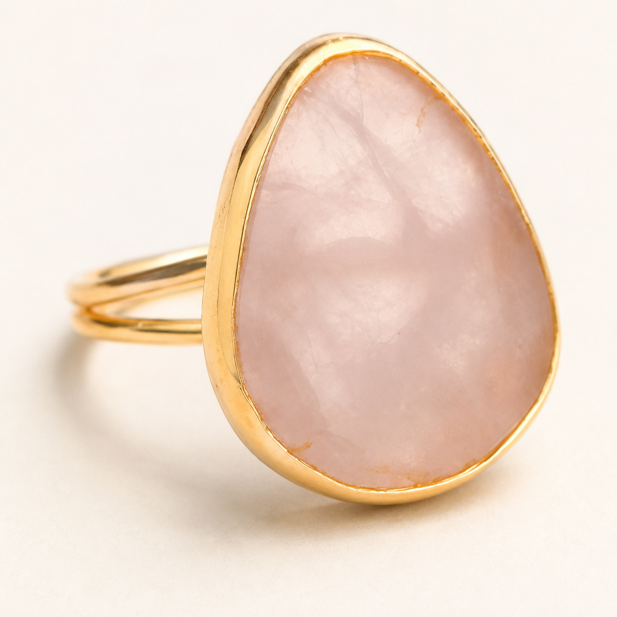 Detail view of a pink teardrop stone ring with gold-tone edging.