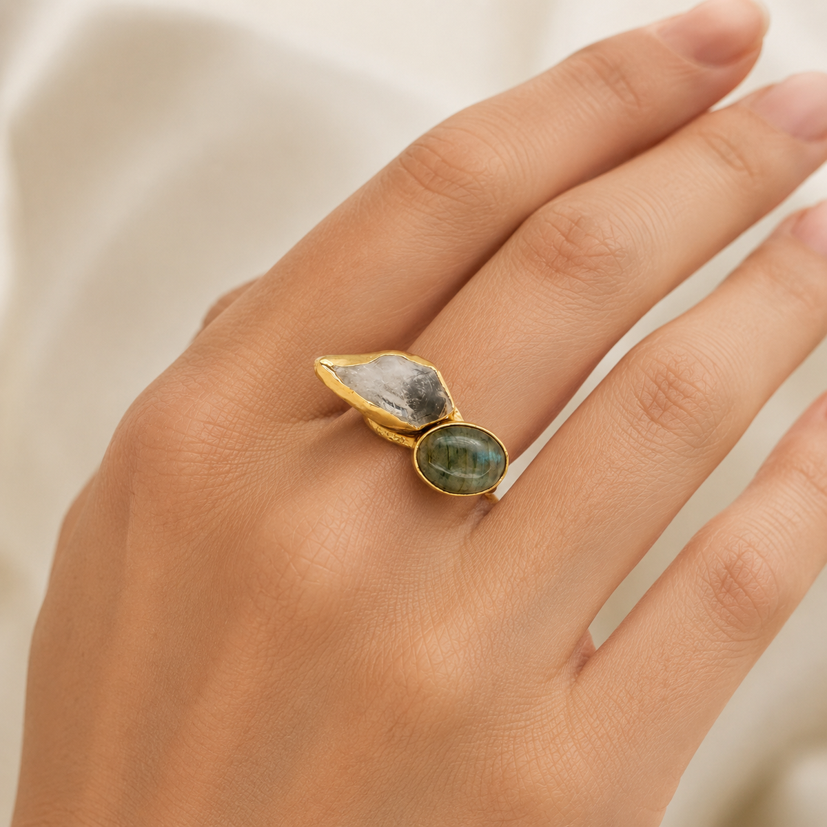 Gold-plated ring with two natural stones shown on a white background.