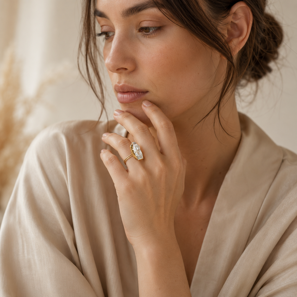 Raw crystal quartz ring with a sculptural gold-plated silhouette.
