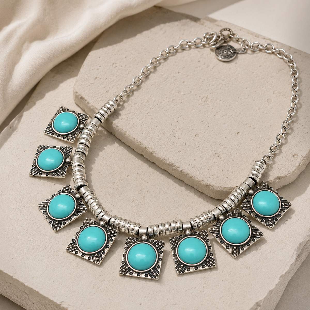 Angle view of the turquoise star charm necklace with textured silver-tone links.