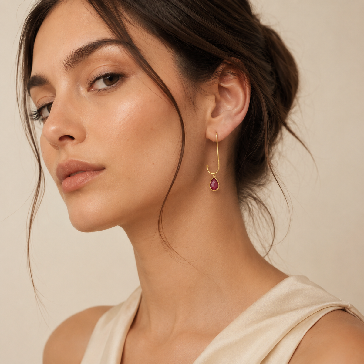 Gold-plated paperclip-style drop earrings with green stones.