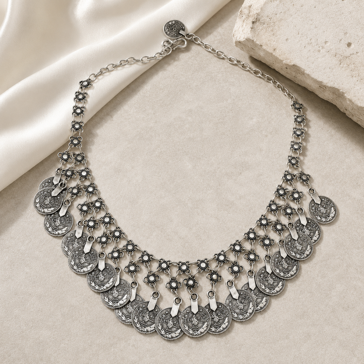 Silver-tone bib necklace with a layered fringe design and floral details.