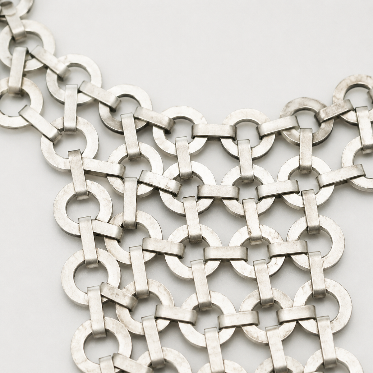 Close view of the silver link necklace links and bib shape.