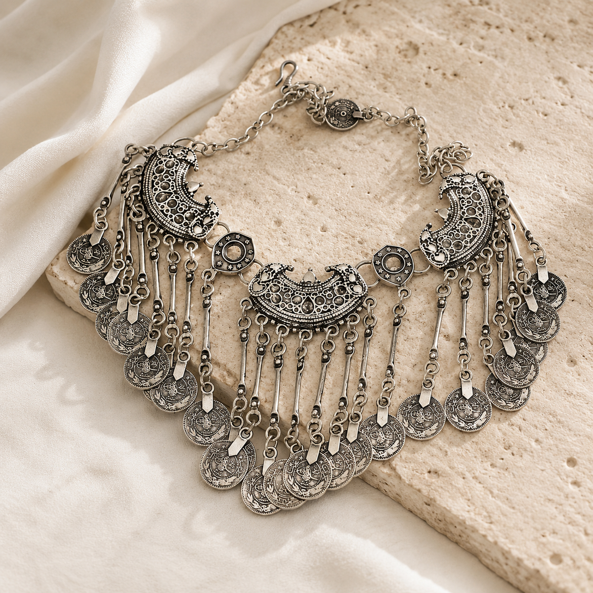 Silver-tone fringe bib necklace with layered decorative coin drops.