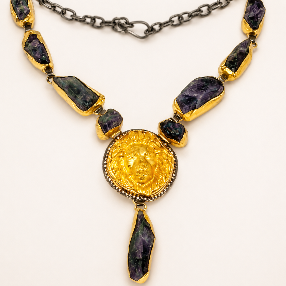 Close view of the purple raw stones and gold-tone pendant details.