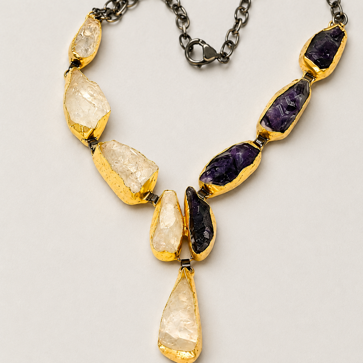 Close view of the necklace showing textured stone-like details and gold-tone settings.