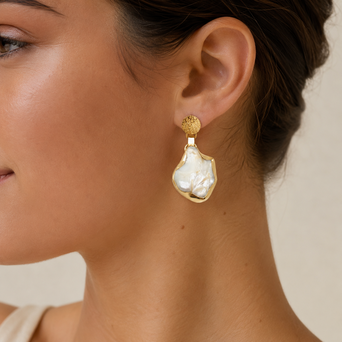 Pair of gold-plated drop earrings with mother of pearl and a softly irregular silhouette.