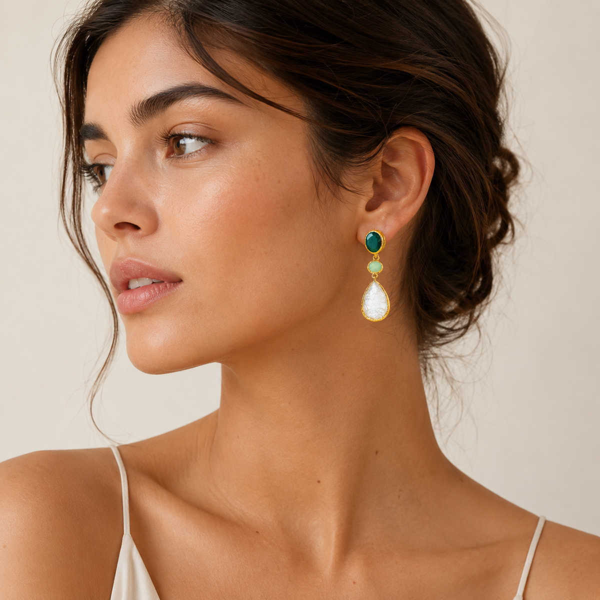 Gold-plated dangle earrings with a faceted stone drop design.