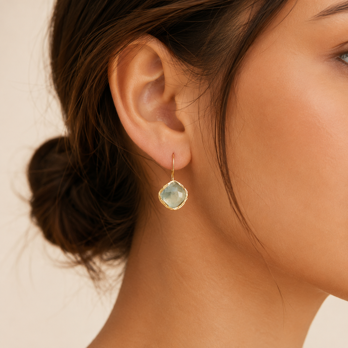 Close view of green aventurine stones set in a gold-plated drop earring frame.