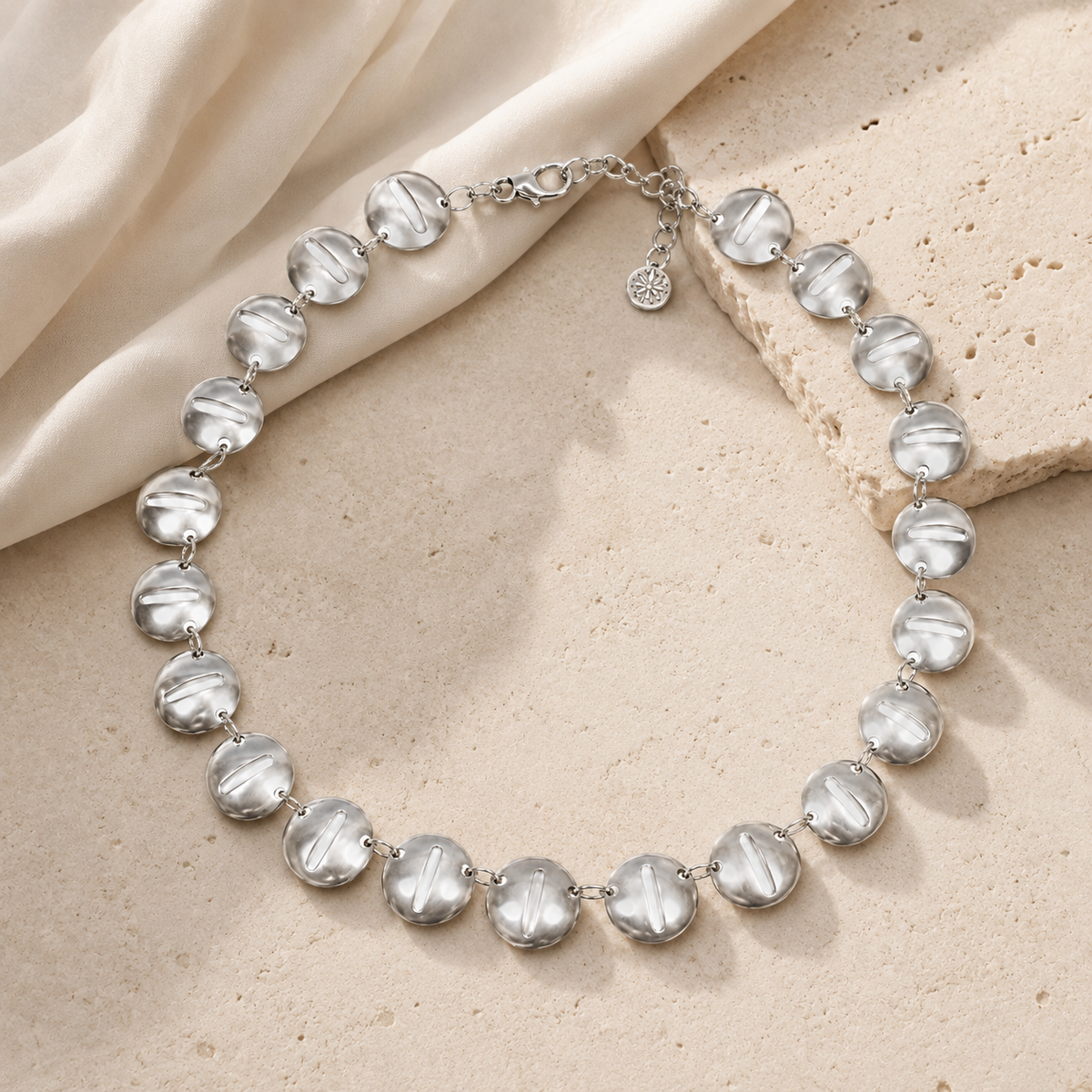 Silver-tone round disc necklace with a sleek, reflective finish.