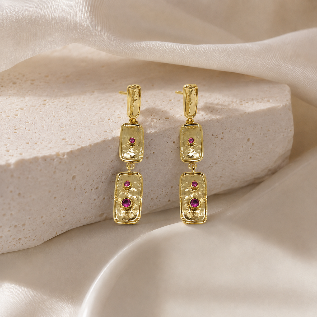 Angle view of triple rectangle pink stone gold-plated earrings.