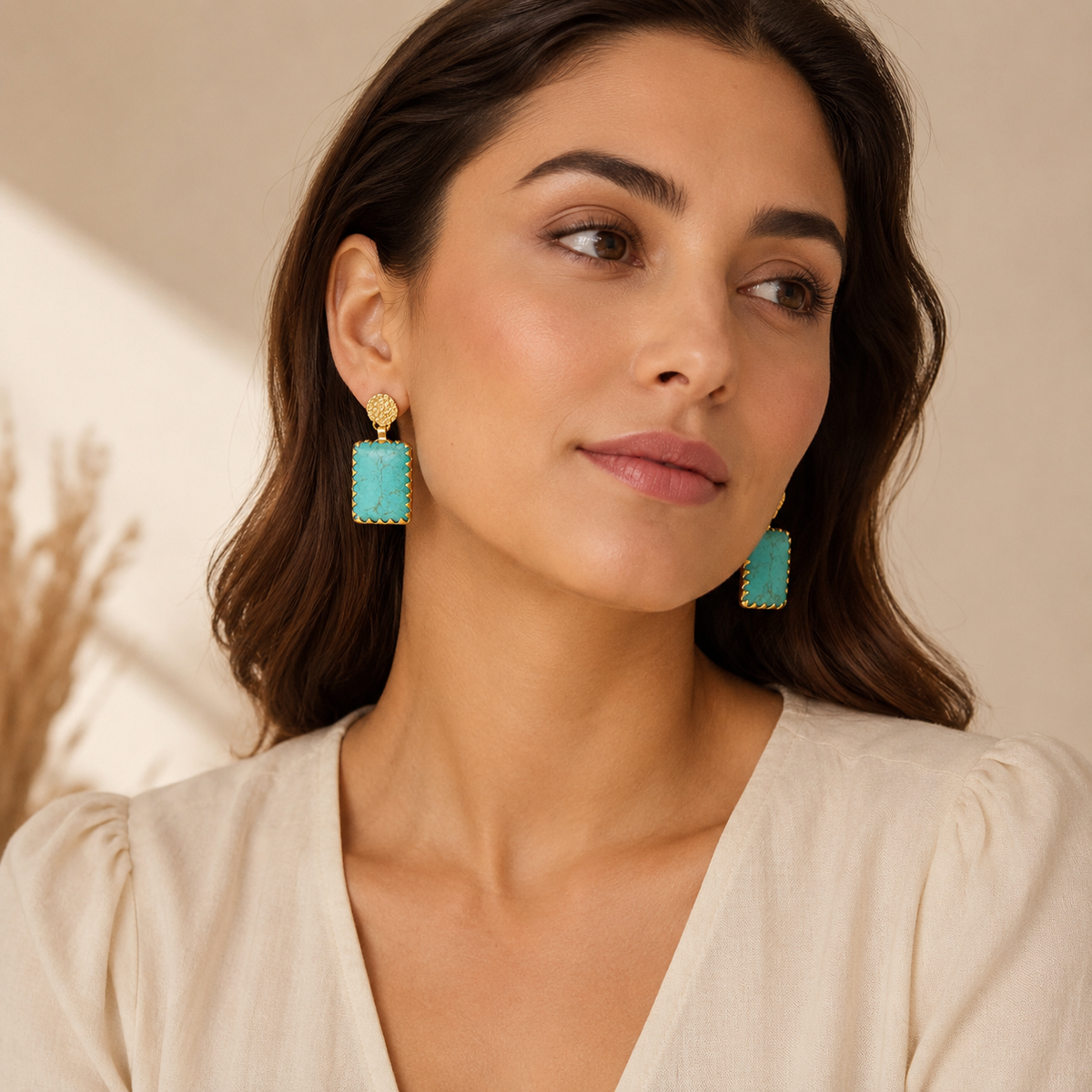 Front view of turquoise and gold statement drop earrings.