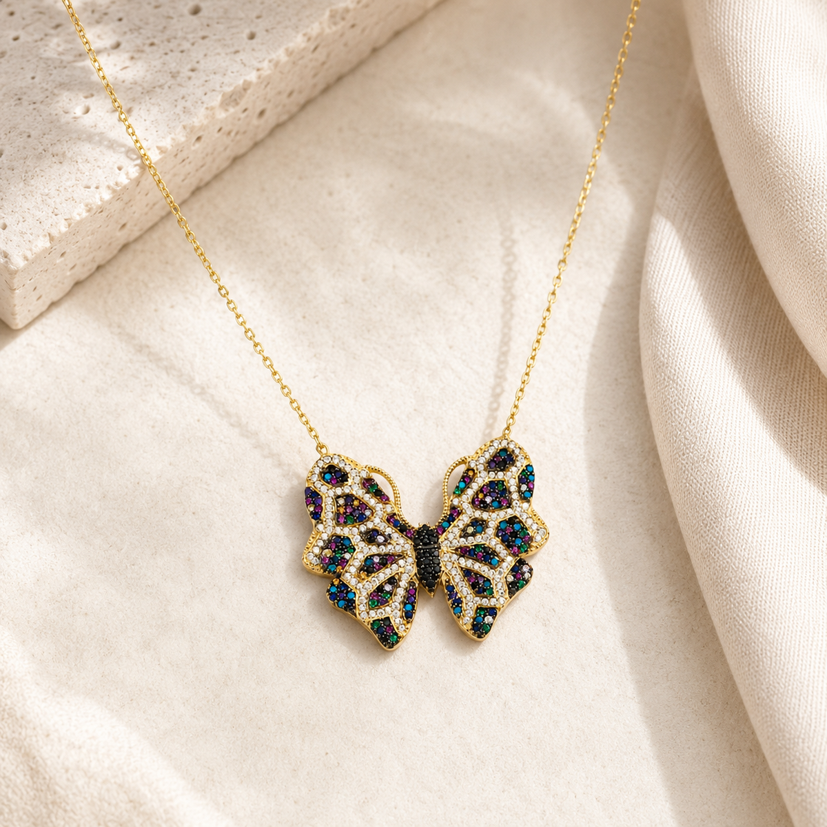 Butterfly pendant necklace with a gold-tone chain and colorful accents.