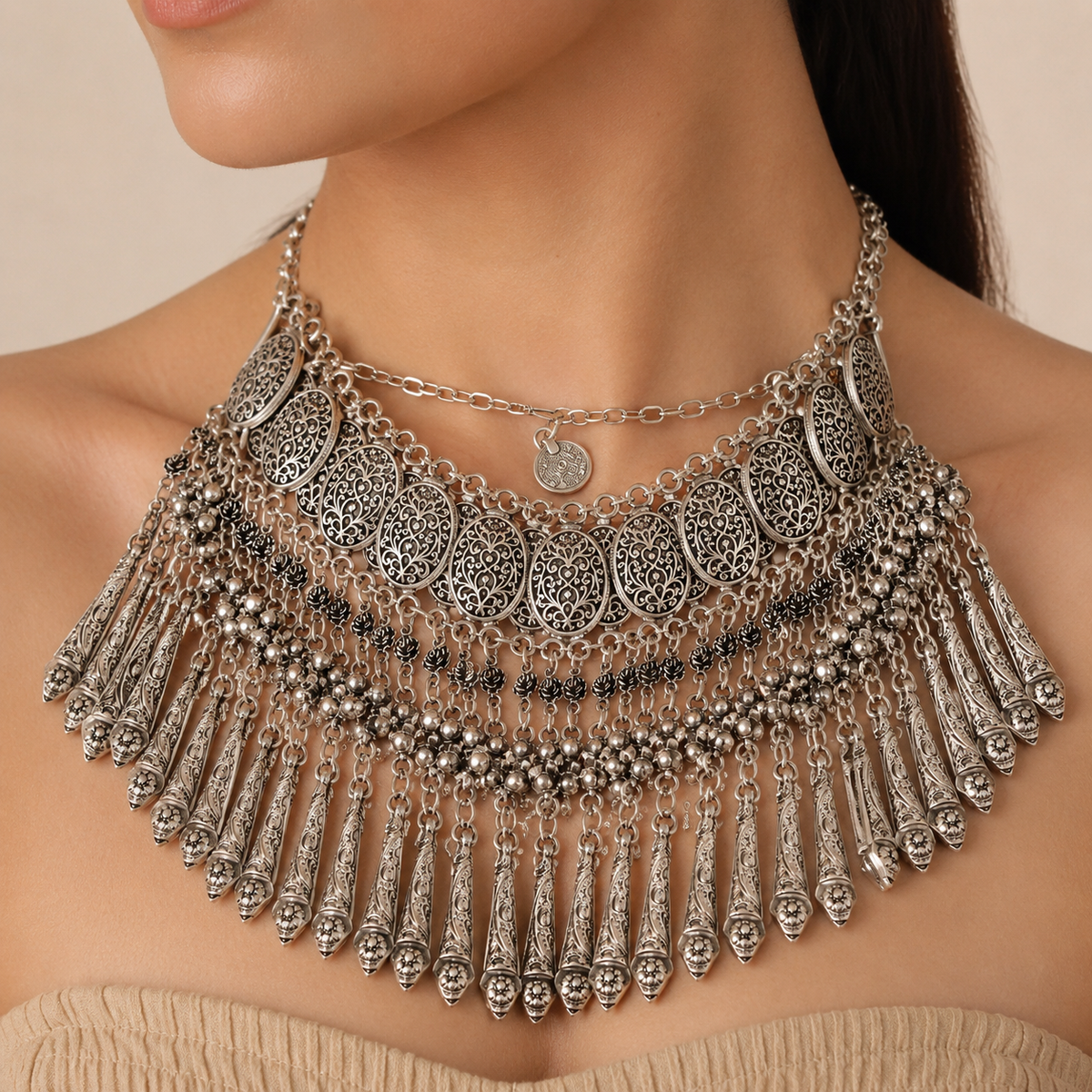 Silver-tone boho necklace with coin fringe and layered textured details.