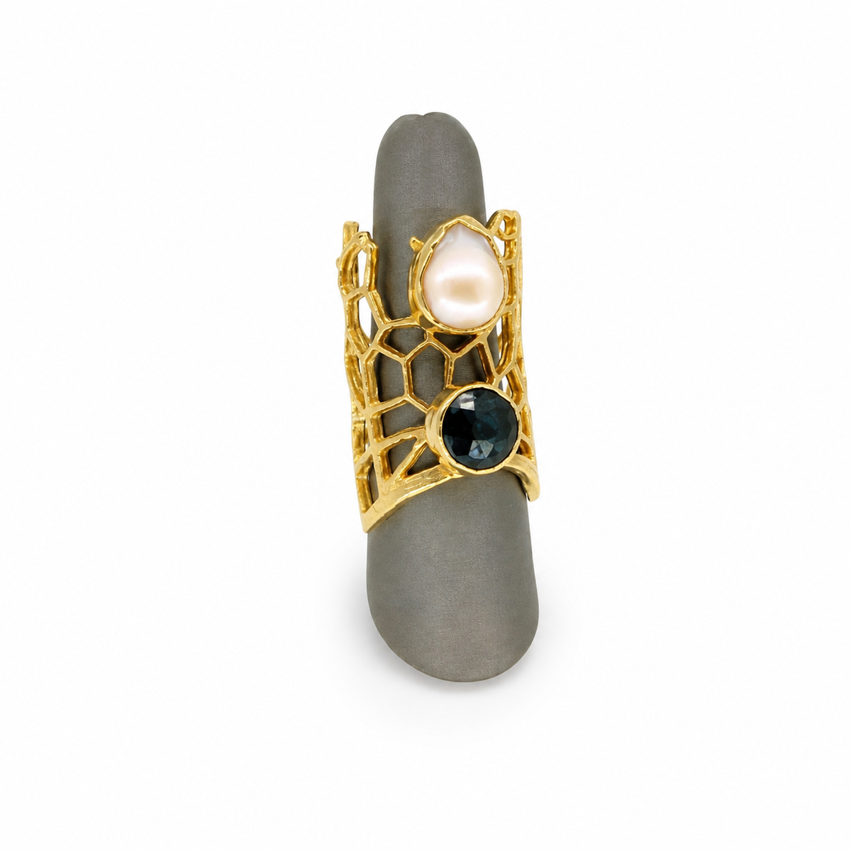 Gold-plated statement ring with honeycomb openwork, a pearl-like stone, and a dark onyx-style accent.