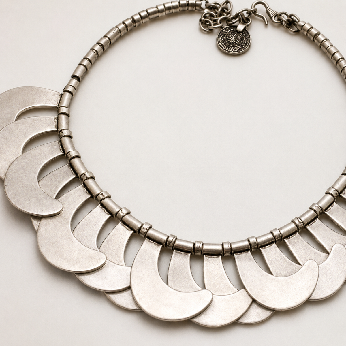 Close view of the necklace’s layered crescent disc details.